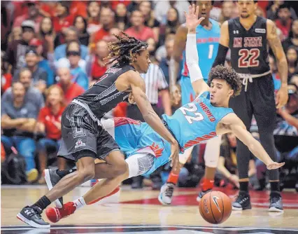  ?? ROBERTO E. ROSALES/JOURNAL ?? New Mexico State’s Terrell Brown, left, collides with the University of New Mexico’s Drue Drinnon and the basketball goes flying. New Mexico State hit 12 of 23 3-point attempts, built a big second-half lead and weathered a Lobos charge to win 98-94.