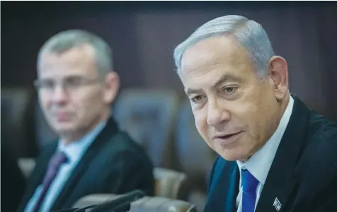  ?? (Yonatan Sindel/Flash90) ?? PRIME MINISTER Benjamin Netanyahu holds last Sunday’s cabinet meeting at the Prime Minister’s Office in Jerusalem, as Justice Minister Yariv Levin looks on.