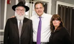  ??  ?? Dovy Ainsworth, center, with his parents, Tzvi Ainsworth, left, and Ingrid ‘Itty’ Ainsworth, who had moved from Australia to be near their children..