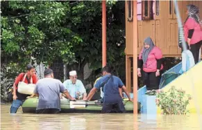  ?? — SAIFUL BAHRI/ The star ?? File photo of a group of villagers helping to evacuate elderly couple from their house in Kampung Gajah, Perak late last year.