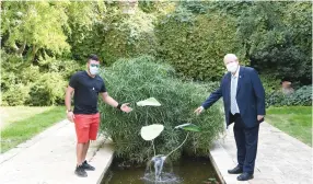  ?? ( Yaron Glass) ?? YARON MEYER and President Reuven Rivlin point to Meyer’s flower sculpture in the garden pool of the presidenti­al compound.