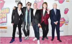  ??  ?? Fashion designer Tommy Hilfiger, center, poses with The Rolling Stones, from left, Ronnie Wood, Keith Richards, Mick Jagger and Charlie Watts at the opening night party for ‘Exhibition­ism’ at Industria on Tuesday in New York. — AP