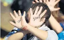 ?? JOE RAEDLE/GETTY IMAGES FILE ?? A student has the words “don't shoot” written on her hands as she joins with other students at Marjory Stoneman Douglas High School in Parkland on a school walkout in March 2018.