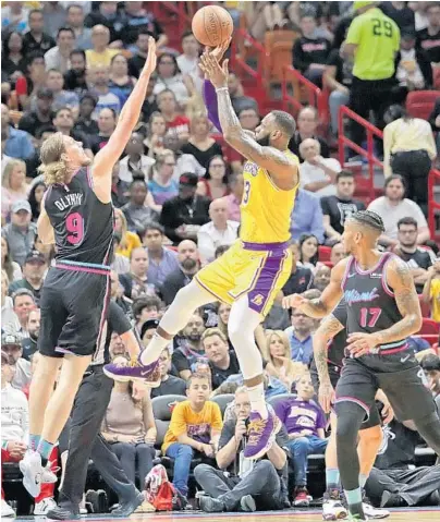  ?? JOHN MCCALL/SUN SENTINEL ?? Los Angeles Lakers forward LeBron James takes a shot over Miami Heat forward Kelly Olynyk during Sunday’s game. James scored 51 points.