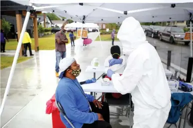  ?? STAFF PHOTO BY C.B. SCHMELTER ?? Nurse Joyce Painter, right, administer­s a COVID-19 test to Mark Wood at the Avondale Youth and Family Developmen­t Center on Wednesday. Cempa Community Care was offering free walk-up and drive-thru testing for COVID-19.