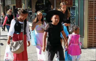  ?? PHOTOS BY MICHILEA PATTERSON — DIGITAL FIRST MEDIA ?? Children walk down E. High Street wearing Halloween costumes for the Haunts on High event in Pottstown on Saturday. The event included a safe trick-or-treating activity from the 100 to 300 block of High street.