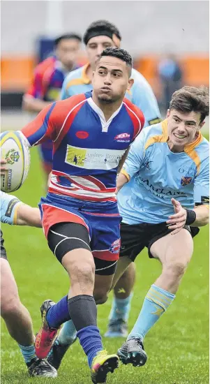  ?? PHOTO: GERARD O’BRIEN ?? er in support as he evades University defenders Cory Smith (left) and Connor th Barr Stadium in Dunedin.