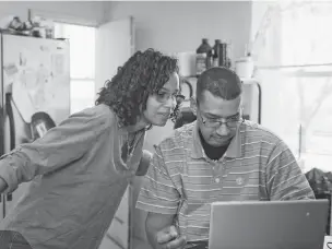  ?? HANNAH YOON/NEW YORK TIMES ?? Carmen Mercado, left, gives some guidance to her brother, Richard Gonzalez, with his online classes in Woodbridge, N.J., on Feb. 9, after his early release from prison.