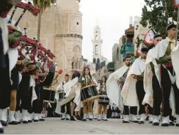  ?? MAJDI MOHAMMED/AP ?? Palestinia­n scouts march Saturday during a Christmas parade toward the Church of the Nativity in the West Bank town of Bethlehem.