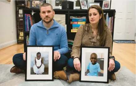  ?? CLIFF OWEN/AP ?? Bryan and Julie Hanlon show images of their adopted Haitian children, Gina, left, and Peterson last week in a play area at their home in Washington. They fear they won’t be able to secure the children’s passports and fly them out of Haiti.