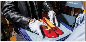  ?? (The New York Times/Roger Kisby) ?? Todd Fisher holds a pair of ruby slippers from “The Wizard of Oz,” part of the late actress Debbie Reynolds’ extensive costume and prop collection, in Las Vegas, Oct. 20, 2020.