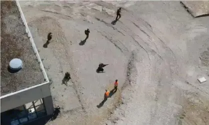  ??  ?? A still from drone footage showing men in military-style gear moving in formation at a former barracks in Mosbach, southern Germany. Photograph: Monitor