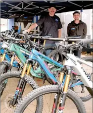  ?? Lynn Atkins/Special to The Weekly Vista ?? Kendall McCann (left), owner of Bison Bikes, and Caleb Richter of Pivot Cycles pose with a few of the bikes available for test rides during a Demo Day at the bike store on Forest Hills Blvd.
