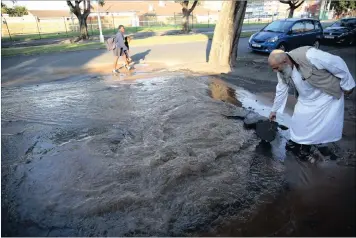  ?? PICTURE: MOTSHWARI MOFOKENG ?? Mohamed Bassa holding a section of the road where a pipe burst at Mitchell Crescent in Greyville.