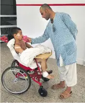  ?? ANNIE GOWAN / THE WASHINGTON POST ?? Abdul Matin comforts his son Fahim, 10, who had surgery at the Emergency Surgical Center for War Victims in Kabul after being hit with shrapnel by an explosive device.