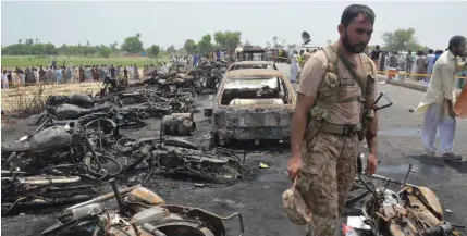  ?? EPA ?? An army soldier stands guard amidst the burnt vehicles at the scene of an oil tanker accident on the outskirts of Bahawalpur, Pakistan, yesterday.