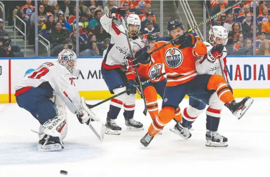  ?? PERRY NELSON/USA TODAY ?? Oilers forward Markus Granlund is knocked off balance in front of Capitals goaltender Braden Holtby during the first period Thursday night at Rogers Place.