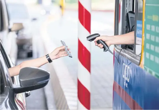  ??  ?? A motorist uses his smartphone to pay the highway toll via Alipay, Alibaba’s online payment service, at Pengbu toll station in Zhejiang, China. Alibaba and WeChat have a lock on Thailand’s mobile third-party payment services for Chinese travellers.