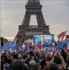  ?? AP photo ?? French President Emmanuel Macron celebrates with supporters in front of the Eiffel Tower in Paris, France, on Sunday. Polling agencies projected that French President Emmanuel Macron comfortabl­y won reelection Sunday in the presidenti­al runoff, offering French voters and the European Union the reassuranc­e of leadership stability in the bloc’s only nuclear-armed power as the continent grapples with Russia's invasion of Ukraine.