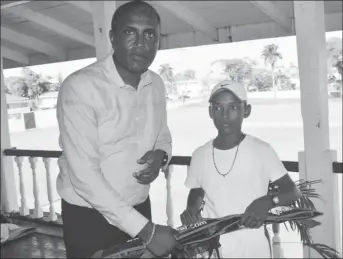  ??  ?? Best under-15 player Daniel Mootoo receives a pair of pair of gloves from Club President Alfred Mentore.