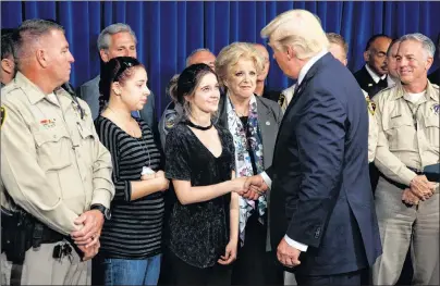  ?? AP PHOTO ?? U.S. President Donald Trump shakes hands after speaking with first responders and private citizens that helped during the mass shooting, during a “Hero’s Meet and Greet” at the Las Vegas Metropolit­an Police Department Wednesday.