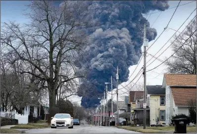  ?? (File Photo/ap/gene J. Puskar) ?? A black plume rises over East Palestine, Ohio, on Feb. 6 as a result of a controlled detonation of a portion of derailed Norfolk Southern trains. Stories circulatin­g online incorrectl­y claim a video of a purple cloud looming over a street as a car drives underneath shows East Palestine after the derailment and intentiona­l burning of some of the hazardous chemicals on board.