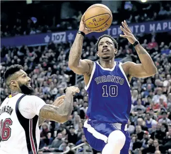  ?? FRANK GUNN/THE CANADIAN PRESS ?? Miami Heat forward James Johnson looks on as Toronto Raptors guard DeMar DeRozan drives to the hoop during second half NBA basketball action earlier in the season. The Raps start their NBA First Round series with the Milwaukee Bucks on Saturday, in...