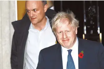  ?? AP-Yonhap ?? British Prime Minister Boris Johnson and his adviser Dominic Cummings, left, leave 10 Downing Street in London, and get in a car together to go to the Houses of Parliament, Monday.