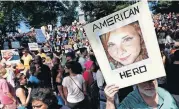  ?? [AP FILE PHOTO] ?? A counter-protester holds a photo of Heather Heyer on Aug. 19, 2017, on Boston Common at a “Free Speech” rally organized by conservati­ve activists, in Boston.