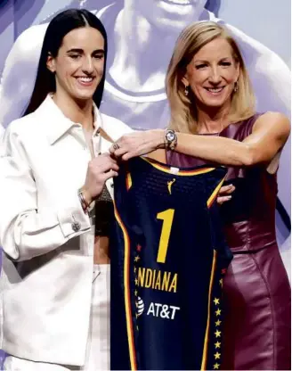  ?? SARAH STIER/GETTY IMAGES ?? Caitlin Clark (left) was welcomed to the WNBA by commission­er Cathy Engelbert after being drafted No. 1 overall by the Indiana Fever.