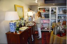  ?? Lake Fong/Post-Gazette ?? Liz Wilson, owner of Wilson &amp; Weir, a pretty, preppy home decor store full of color in Sewickley, adjusts a lamp shade in the shop.