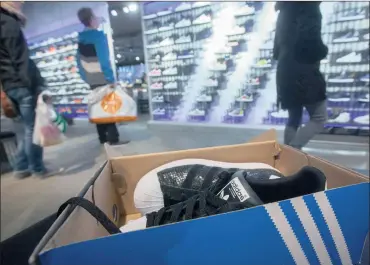  ?? PHOTO: BLOOMBERG ?? Customers browse trainers as footwear sits on display inside an Adidas originals store in Berlin last week. With interest rates on savings low, unemployme­nt falling, oil prices sliding and pay rises outpacing inflation, economists say German consumers...