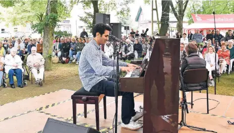  ?? FOTO: JOCHEN EMDE ?? Aeham Ahmad, der Pianist aus den Trümmern, gab auf dem Platz vor der Herz-Jesu-Kirche in Dinslaken Oberlohber­g ein Konzert.