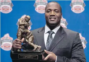  ?? SEAN KILPATRICK, THE CANADIAN PRESS ?? B.C. Lions offensive tackle Jovan Olafioye, seen here with trophy for Most Outstandin­g Offensive lineman, has been living out of a suitcase ever since he returned to the West Coast.