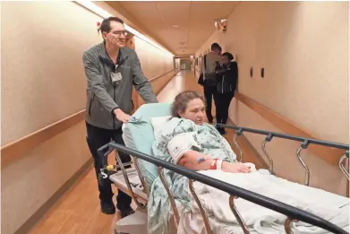  ?? PHOTOS BY MICHAEL SEARS / MILWAUKEE JOURNAL SENTINEL ?? John Melara, an imaging assistant at Aurora West Allis Medical Center, wheels Ricky Myers to her imaging appointmen­t. He sings for his patients on the way. Patients, except for the rare few, he said, seem to really like it. By the time Myers returned, she did indeed seem happier with a smile on her face.