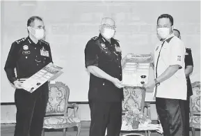  ?? — Gambar Bernama ?? SIMBOLIK: Zainal (dua kiri) menyerahka­n poster‘Program Satu Taman Satu Polis’kepada Abd Hafiz (kanan) pada Majlis Pelancaran Program Satu Taman Satu Polis dan Fokus Polis Diraja Malaysia Kontinjen Melaka 2021, di Melaka semalam. Turut hadir Abdul Majid (kiri).