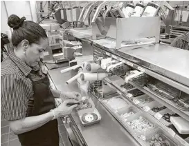  ?? Charles Rex Arbogast / Associated Press file ?? Silvia Ruiz prepares a sandwich at a McDonald’s restaurant in Chicago. The chain’s revenue fell 3 percent to $6.05 billion, as sales gains at restaurant­s owned by franchisee­s were offset by a decline at company-run stores. But its profit rose.