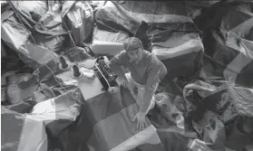  ?? Jerry Telfer / The Chronicle 1998 ?? Artist Gilbert Baker sews rainbow flags for a 1998 Market Street installati­on.