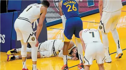  ?? JEFF CHIU THE ASSOCIATED PRESS ?? Players watch as Denver Nuggets guard Jamal Murray remains on the floor after being injured during the second half of an NBA game against the Golden State Warriors in San Francisco on Monday.