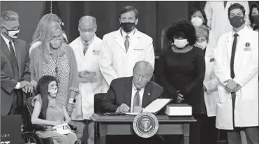  ?? AP-Chris Carlson ?? President Donald Trump signs an executive order after delivering remarks on healthcare Thursday in Charlotte, N.C.