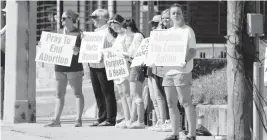  ?? ROGELIO V. SOLIS AP ?? Members of the Dayspring Community Church youth group of Clinton, Miss., stand outside the Jackson Women’s Health Organizati­on clinic in Jackson, holding signage that opposes abortion on Wednesday. The clinic is the only facility that performs abortions in the state.