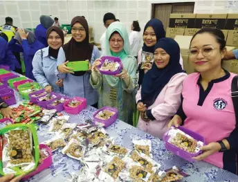  ?? Tugong — Photo by Agnes ?? Fatimah (third left) poses with the volunteers during the Sumbangsih Raya 2024 programme.