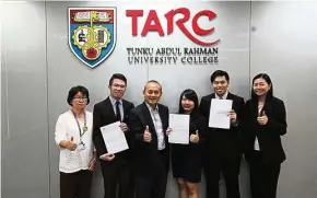  ??  ?? Ng Kok Loong (fifth from left), Ong Shu Yee (fourth from left) and Lim Ka Way (second from left), showing the letters from the Malaysian Institute of Chartered Secretarie­s and Administra­tors notifying them of their achievemen­ts. They are flanked by TAR...