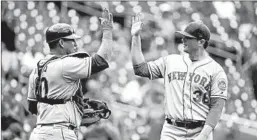  ?? PATRICK SEMANSKY/AP ?? Wilson Ramos, left, and Justin Wilson celebrate the Mets’ victory Wednesday.