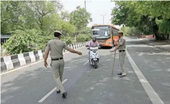  ?? — AFP ?? Police stop vehicles to check commuters as a weekend lockdown is in effect wherein only people catering to essential services were allowed to commute in New Delhi.