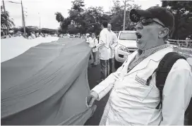  ?? AP PHOTO/FERNANDO VERGARA ?? Venezuelan doctors shout slogans Sunday against the government of Venezuela’s President Nicolas Maduro at the Internatio­nal Bridge Tienditas, which has been blocked by the Venezuelan military, near Cucuta, Colombia.