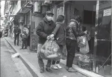  ?? GAO ERQIANG / CHINA DAILY ?? A couple buys groceries in Shanghai on Monday. It was the second time in the past month they had left home.