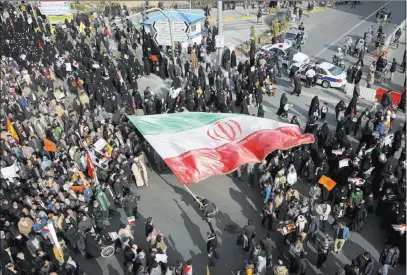  ?? Nima Najafzadeh ?? The Associated Press A demonstrat­or waves a huge Iranian flag during a pro-government rally Thursday in the northeaste­rn city of Mashhad, Iran.