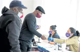  ?? Jessica McGowan, Getty Images ?? Voters check in with poll workers to cast their ballots at the Metropolit­an Library on Nov. 3 in Atlanta.