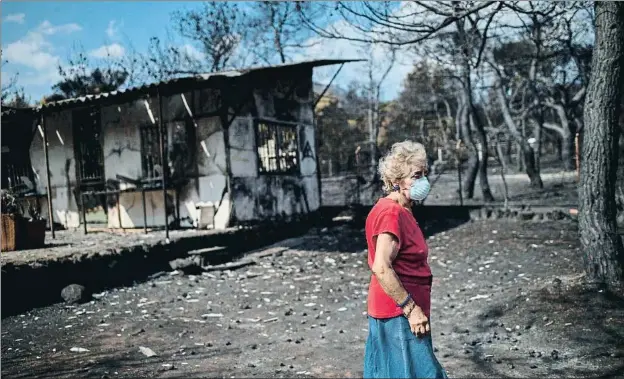  ?? ANGELOS TZORTZINIS / AFP ?? Una mujer ante su casa quemada, ayer en la localidad de Neos Voutzas, una de las más afectadas junto con Mati y Rafina